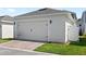 Two-car garage with brick paved driveway, well-maintained lawn and side access at 15444 Lebeau Loop, Winter Garden, FL 34787