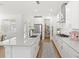 Contemporary white kitchen with stainless steel appliances, stylish cabinetry, and an island with a sink at 15444 Lebeau Loop, Winter Garden, FL 34787