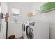Clean laundry room featuring a washer, dryer, and storage shelves at 15444 Lebeau Loop, Winter Garden, FL 34787