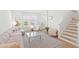 Open-concept living room with light wood floors, modern furnishings, and large windows, creating a bright and inviting space at 15444 Lebeau Loop, Winter Garden, FL 34787
