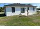 Back exterior view of home showing a grassy yard and sliding glass door access to the house at 1750 Mitten Ter, Deltona, FL 32738
