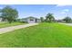Well-maintained front yard featuring lush green grass, mature trees, and a neatly paved driveway at 1750 Mitten Ter, Deltona, FL 32738