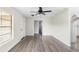 Neutral living room with wood-look floors, a ceiling fan and a hallway view of the kitchen at 1750 Mitten Ter, Deltona, FL 32738