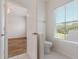 Bright bathroom with a white toilet, tiled floors and a large window at 181 Longview Ave, Kissimmee, FL 34747