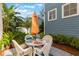 Outdoor patio area with dining table, umbrella, and tropical landscape at 181 Longview Ave, Kissimmee, FL 34747