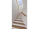 Bright, contemporary staircase with white risers and wood-look treads and handrail at 181 Longview Ave, Kissimmee, FL 34747