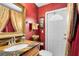 Unique half-bathroom featuring a vibrant red wall, decorative accents, and a vanity sink at 2214 Westbourne Dr, Oviedo, FL 32765