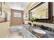 Bathroom featuring dual sinks with granite counters and a decorative framed mirror at 2214 Westbourne Dr, Oviedo, FL 32765