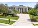 A sprawling two-story home features a prominent entryway, manicured lawn, and oversized driveway at 2214 Westbourne Dr, Oviedo, FL 32765