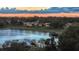 An aerial view of the community featuring a lake, pier, and homes at dusk at 245 Via Siena Ln, Lake Mary, FL 32746