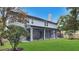 Expansive backyard features lush green lawn, mature trees, and a charming screened-in porch at 245 Via Siena Ln, Lake Mary, FL 32746