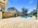 Inviting backyard oasis with a sparkling pool, brick patio, and lush landscaping, ideal for relaxation and enjoyment at 2520 Chanute Trl, Maitland, FL 32751