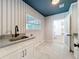 Well-lit laundry room features striped wallpaper, window, sink with modern faucet, and tile flooring at 2520 Chanute Trl, Maitland, FL 32751