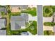 Overhead view of home with large patio, manicured lawn, verdant landscaping, and paved driveway at 2528 Buttonwood Run, The Villages, FL 32162