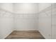 Walk-in closet features wood-look flooring and wire shelving at 2528 Buttonwood Run, The Villages, FL 32162