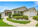 Landscaped front yard and walkway leading to the charming home with a screened-in lanai at 2528 Buttonwood Run, The Villages, FL 32162