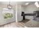 Modern kitchen featuring stainless steel appliances, stone countertops, and white cabinetry at 2528 Buttonwood Run, The Villages, FL 32162