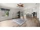 Open-concept living space featuring hardwood floors, ceiling fan, and large windows at 2528 Buttonwood Run, The Villages, FL 32162