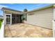 Charming outdoor patio with decorative concrete, leading to a screened-in lanai and lush landscaping at 2528 Buttonwood Run, The Villages, FL 32162
