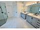 Bright bathroom with modern fixtures, double sink vanity, white marble floors and glass shower at 2643 Aloma Oaks Dr, Oviedo, FL 32765
