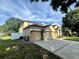 Two-story home featuring a spacious three-car garage, manicured lawn, and mature trees at 2643 Aloma Oaks Dr, Oviedo, FL 32765