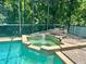 Hot tub with a rock waterfall feature, in a screened in pool area at 2643 Aloma Oaks Dr, Oviedo, FL 32765