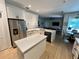 Open-concept kitchen boasts stainless steel appliances, quartz countertops, and wooden floors at 2643 Aloma Oaks Dr, Oviedo, FL 32765