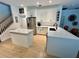 Open kitchen with island, white cabinets, stainless steel appliances, and modern bar stools at 2643 Aloma Oaks Dr, Oviedo, FL 32765
