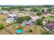 An aerial view showing a neighborhood with mature trees and a home with solar panels and an above-ground pool at 2771 Ne 66Th St, Ocala, FL 34479
