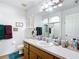 Bright bathroom with a wooden vanity, a large mirror, and a shower, creating a clean, functional space at 2771 Ne 66Th St, Ocala, FL 34479