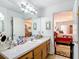 Bathroom featuring a wood vanity, bright mirror, and connecting door with bedroom view, providing a functional layout at 2771 Ne 66Th St, Ocala, FL 34479