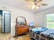 Bedroom with wood floor and dresser, a small TV, and plenty of natural light at 2771 Ne 66Th St, Ocala, FL 34479