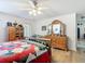 Bright bedroom with a light ceiling fan, wooden furniture, and a colorful quilt, offering a comfortable retreat at 2771 Ne 66Th St, Ocala, FL 34479