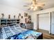 Bedroom features wood floor, a ceiling fan, a dresser, and a closet with shelving at 2771 Ne 66Th St, Ocala, FL 34479