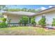 This exterior features a well manicured lawn, lush landscaping, and a chair on the porch at 2771 Ne 66Th St, Ocala, FL 34479