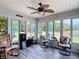 Comfortable sunroom with large windows, ceiling fan, and a cozy seating area at 2771 Ne 66Th St, Ocala, FL 34479