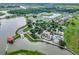 A beautiful aerial view of a community featuring a pool, lake, and mature trees at 2901 Agostino Ter, Kissimmee, FL 34746