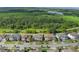 An aerial view of a street featuring homes near a lush forest and lake at 2901 Agostino Ter, Kissimmee, FL 34746