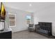 Bright Bedroom with dark wood crib, cozy armchair and lots of natural light at 2901 Agostino Ter, Kissimmee, FL 34746