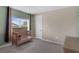 Bedroom with a crib, green accent wall, carpet floors and natural light from window at 2901 Agostino Ter, Kissimmee, FL 34746