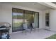 A cozy patio with chairs, gas grill and sliding glass door to the backyard at 2901 Agostino Ter, Kissimmee, FL 34746