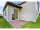 Brick back patio framed with grass and featuring sliding glass door to home's interior at 2914 Scarlett Dr, St Cloud, FL 34772