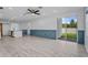 Spacious living room with open floor plan, light-colored floors, blue paneling, and a sliding glass door to the backyard at 2914 Scarlett Dr, St Cloud, FL 34772