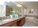 Bathroom with granite countertop, double vanity and soaking tub with tiled surround at 2928 Buccaneer Palm Rd, Kissimmee, FL 34747