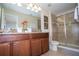 Well-appointed bathroom with double vanity, granite countertops, and a glass-enclosed shower at 2928 Buccaneer Palm Rd, Kissimmee, FL 34747