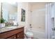 Well-lit bathroom with a granite countertop, dark wood cabinets and tub/shower combo at 2928 Buccaneer Palm Rd, Kissimmee, FL 34747