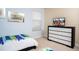 Bedroom with twin bed, a dresser with a television, and light blue walls at 2928 Buccaneer Palm Rd, Kissimmee, FL 34747