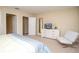 Bedroom with TV featuring a sleek white chair, door and ensuite bathroom at 2928 Buccaneer Palm Rd, Kissimmee, FL 34747