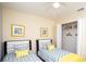 Twin beds bedroom featuring bright yellow accents, ceiling fan, closet, and modern decor at 2928 Buccaneer Palm Rd, Kissimmee, FL 34747
