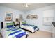Charming bedroom with twin beds, stylish decor, and a ceiling fan at 2928 Buccaneer Palm Rd, Kissimmee, FL 34747